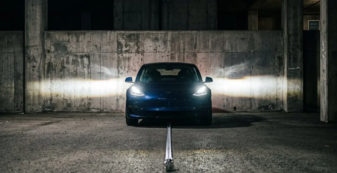 Véhicule garé face à un mur avec faisceau lumineux projeté montrant la technique de réglage des phares